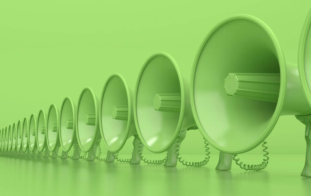 Many monochrome green megaphones stand in a row. Loudspeakers on a green background. Conceptual illustration with copy space. 3D rendering
