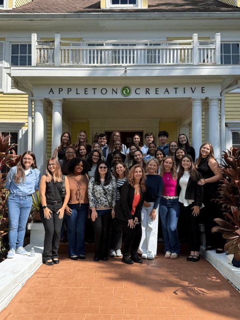 University of Florida students and Diana LaRue, CEO of Appleton Creative, smile outside of the Appleton Creative house after a student tour.